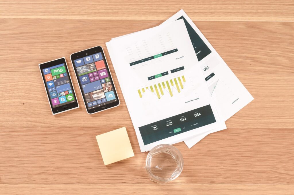 Two iPhones on a desk with a marketing report.